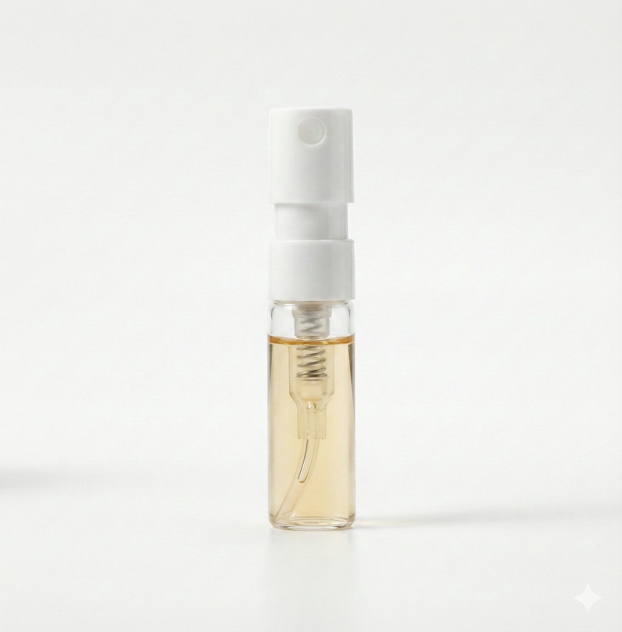 Small spray bottle with a white cap and clear body on a white background